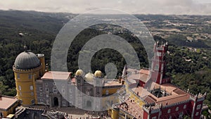 People visiting Pena Palace, Sintra, against Natural Park forest. Aerial view