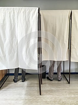 People voting in polling booths at a voting station