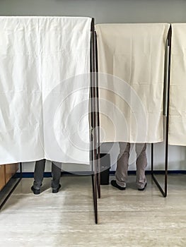People voting in polling booths at a voting station photo