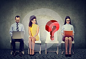 People waiting for business job interview with one empty question mark chair