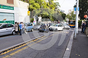 People waiting for the carabinieri at the site of a accident between a scooter and a car