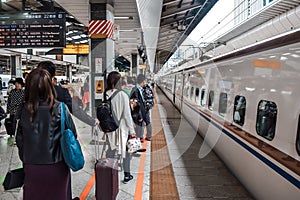 People waiting for Shinkansen bullet train on a platform in Tokyo Japan