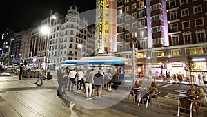 2019 09  Madrid  Spain. Madrid street by night with vehicle motion blur. Pedestrian waiting at traffic lights on Gran Via Street
