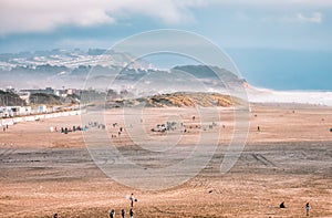 People walk along the beach at Ocean Beach, San Francisco. Pacific Ocean.