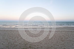 A people walk along the beach at Sunset pastel clear beautiful sky, beach and the blue sea in Huahin, Thailand