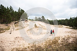 People walk along the dunes in Irbene, Latvia