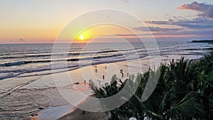 People walk along Echo Beach before sunset. Aerial Shot Of Tourists enjoy time before sunset at the popular beach in