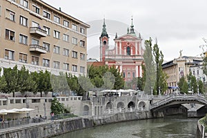 People walk along Ljubljanica river in Ljubljana, Slovenia