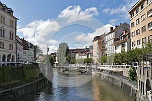 People walk along Ljubljanica river in Ljubljana, Slovenia