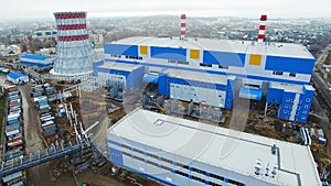 People walk along thermal power plant territory past departments