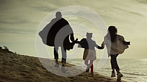 People walk beach happily. Family having fun on sea holiday together outdoors.