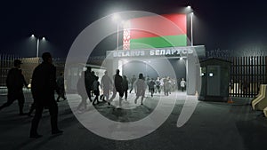 People walk through the border checkpoint gate to Belarus at night - 3D rendered