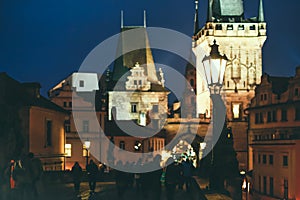 People walk on Charles Bridge, Prague at night