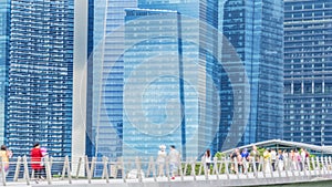 People walk in city pedestrian bridge with exterior modern build