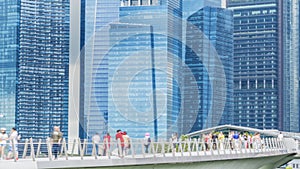 People walk in city pedestrian bridge with exterior modern build