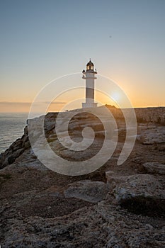 People walk down the street towards the Cap de Barbarie Lighthouse in Formentera in the summer of 2021