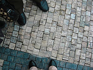 People on a walk. Men`s and women`s legs in autumn shoes on the pavement