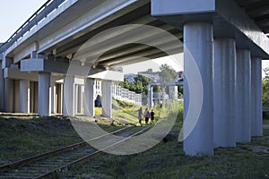 People walk on rails under a road bridge in Tyumen, Russia