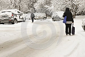 People walk on unclean street covered with danger ice after snowfall