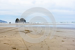 People walk on water in the Northwest Pacific coast with rocks sticking out of the water at low tide and breathe the healing sea