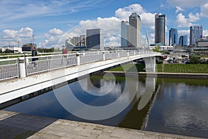People walk by the white bridge in Vilnius, Lithuania.