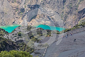 People walking across Irazu Volcano National Park near to viewer of crater photo