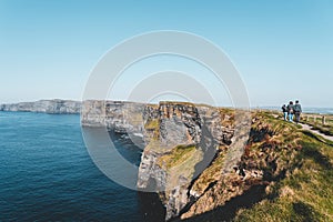 people walking along the cliffs of moher