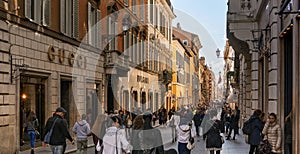 people walking along the elegant shopping avenue Via di Condotti in Rome