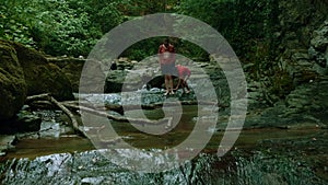 People walking barefeet in rocky mountainous river. Creative Summer hiking, cold stream in forest.