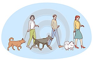 People walking with dogs on leashes
