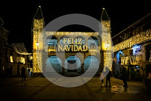 People walking and enjoying the Christmas lights in the medieval old town of Puebla de Sanabria. Zamora. Spain. Luminous text sayi