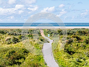 People walking on footpath to North Sea beach of Schiermonnikoog, Netherlands photo