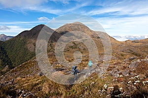 People walking with great backpacks in mountain landscape - trekking hiking mountaneering in mantiqueira range Brazil