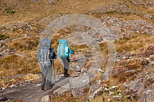 People walking with great backpacks in mountain landscape - trekking hiking mountaneering in mantiqueira range Brazil