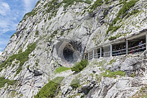 People at hiking trail through Austrian mountains to ice cave