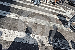 People walking over a cross walk on Fifth Avenue in New York City.