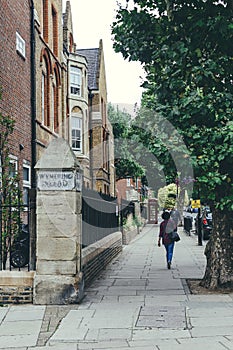 People walking past The City of Westminster College campus on Elgin Avenue in London