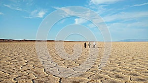 People walking on polygons of salt flat , Iran