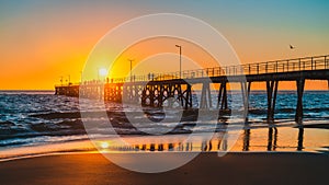 People walking on Port Noarlunga jetty at sunset