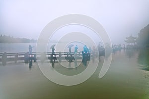 People walking in the rain on the bridge