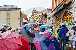 People walking on rainy day with umbrellas on staircase of Rialto Bridge Ponte de Rialto in Venice, Italy