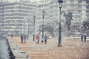 People walking in the snow in the center of the city on a winter day