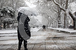 People walking in the snow in the center of the city on a winter day