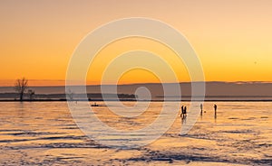 People walking on the St Lawrence River at the Lachine Canal Montreal in Warm Winter Sunset