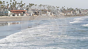 People walking strolling. Pacific ocean, sea water wave. Beachfront vacations resort. California USA