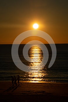 People walking at sunset on the beach of Cadiz capital, Andalusia. Spain.