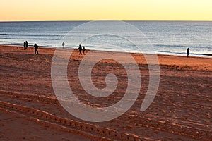 People walking at sunset on the beach of Cadiz capital, Andalusia. Spain.