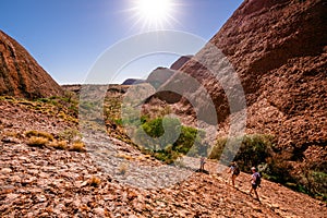 People walking under blazing sun on hot summer sunny day in the Olgas central outback Australia