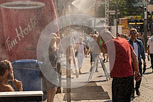 People walking under misting system to cool off during heatwave