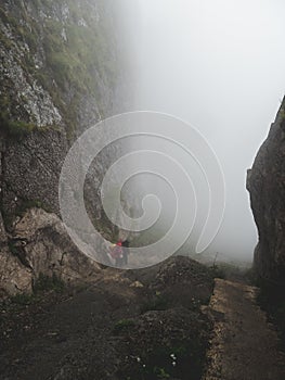 People walking up a steep mountain hiking path covered in fog and rain, swiss alps brienzer rothorn vertical